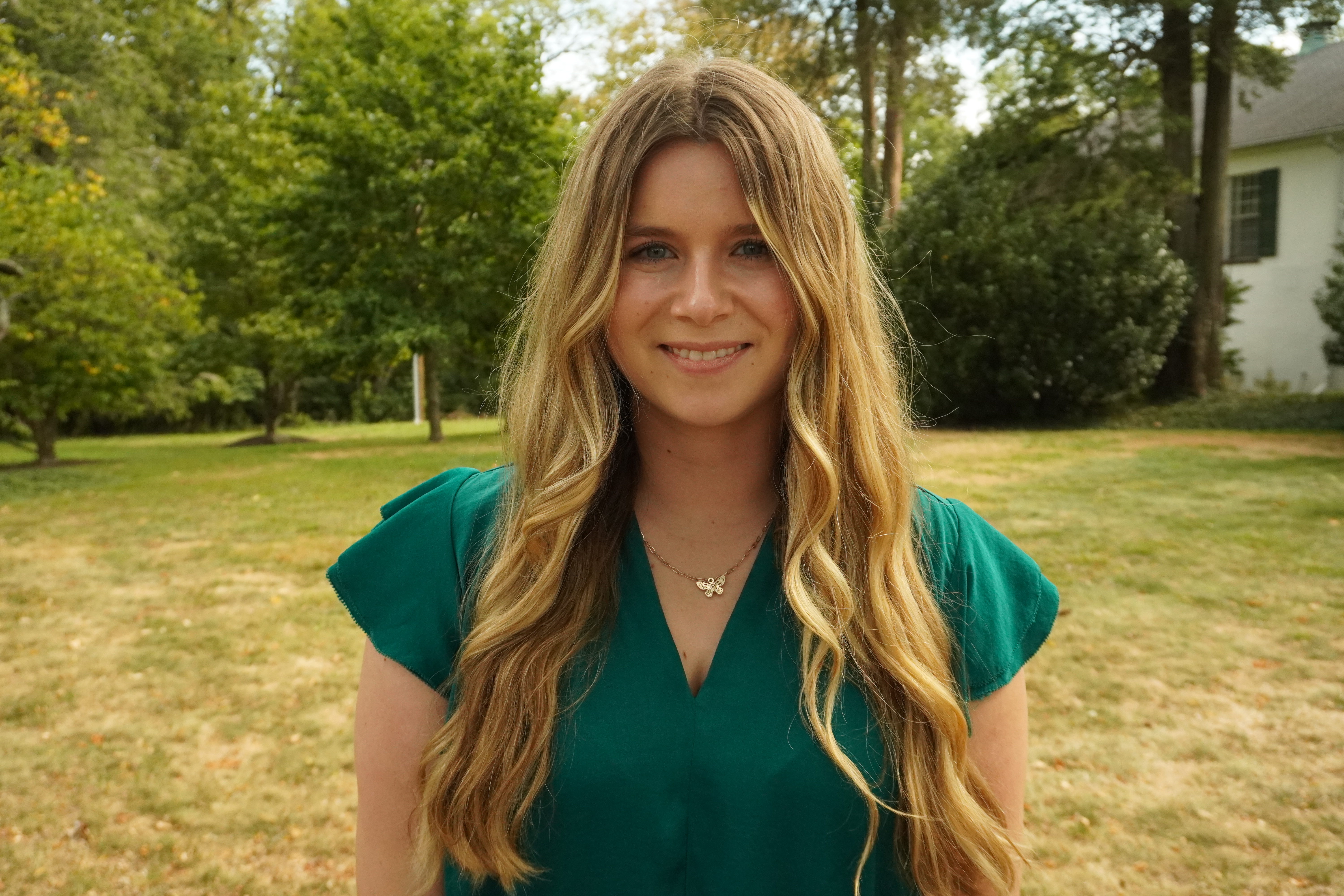 A headshot of Maggie Brown in front of the admissions cottage.