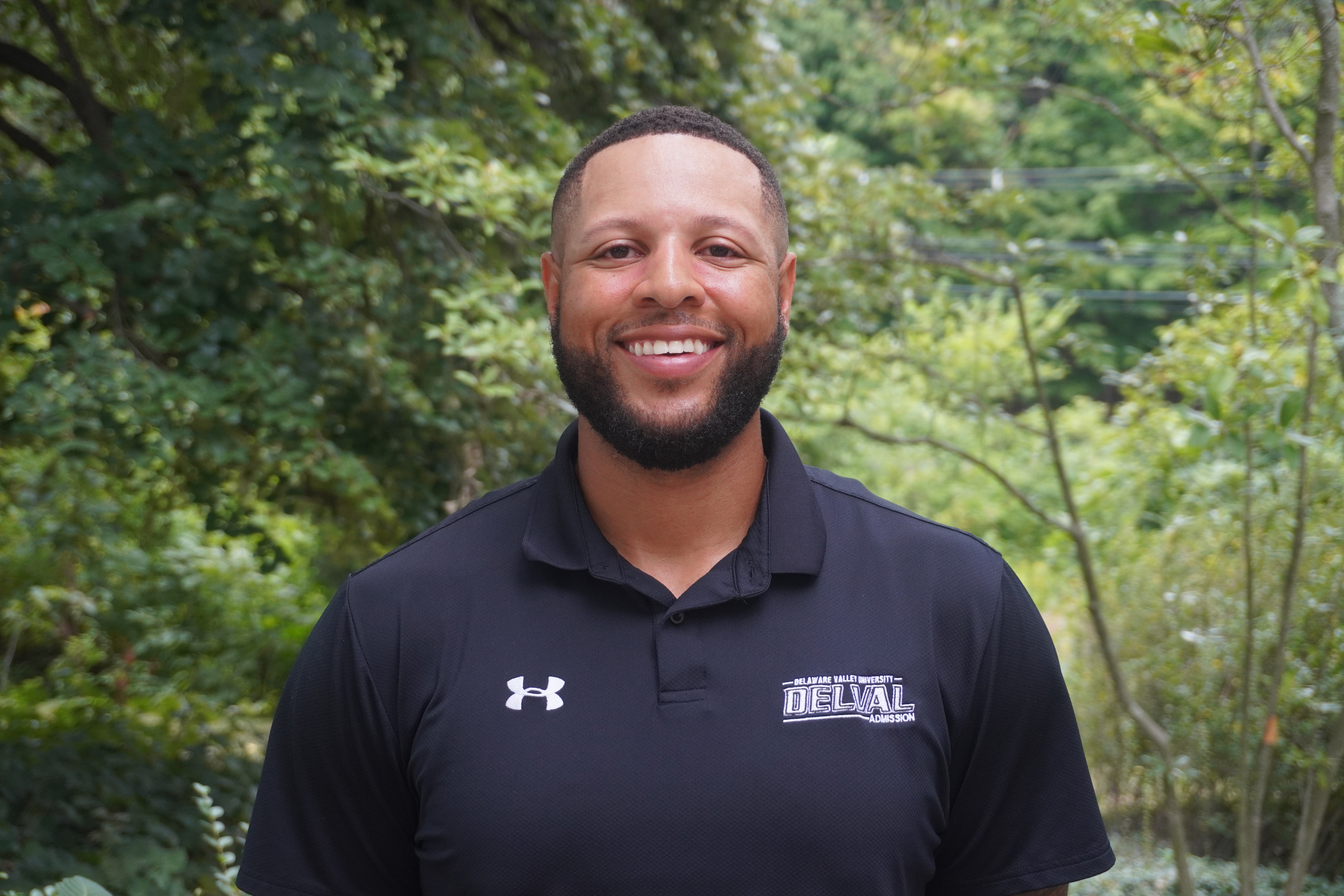 A headshot of Matthew Owens in front of the admissions cottage.