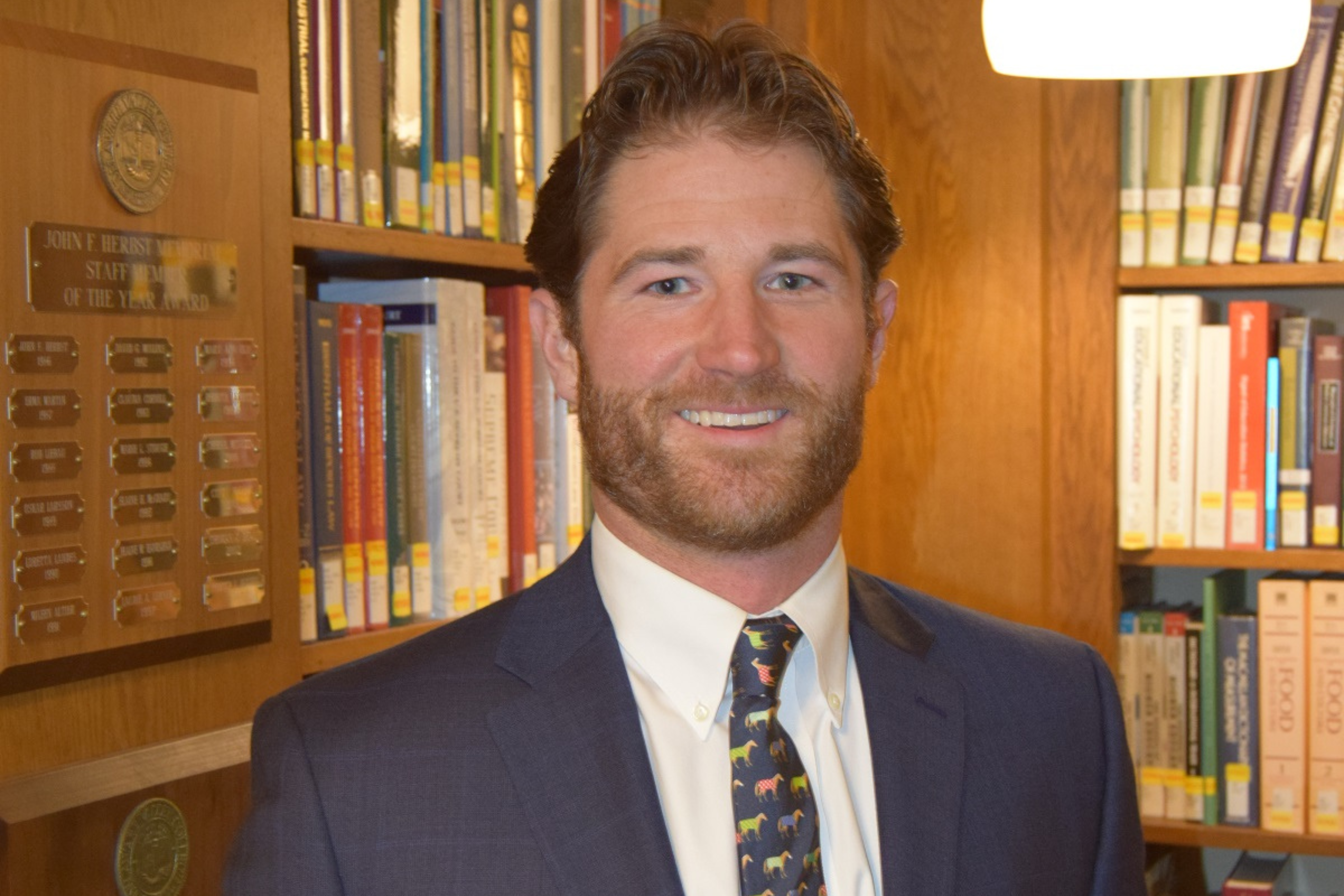 A photo of Thomas O'connor standing in the library at DelVal.
