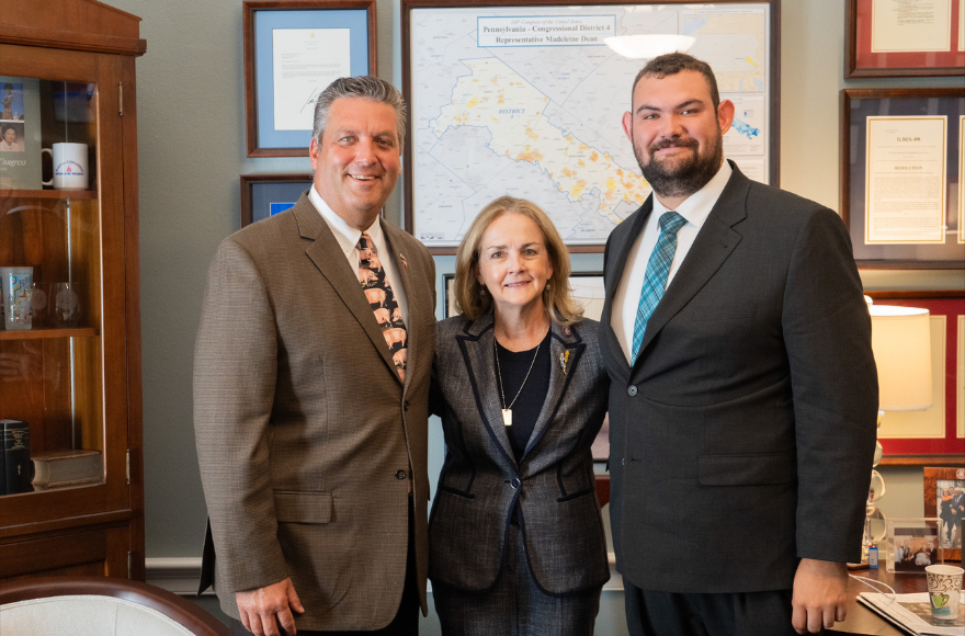 Alumnus, greg gipe, is standing with two law enforcement employees in an office setting. All are wearing business attire.