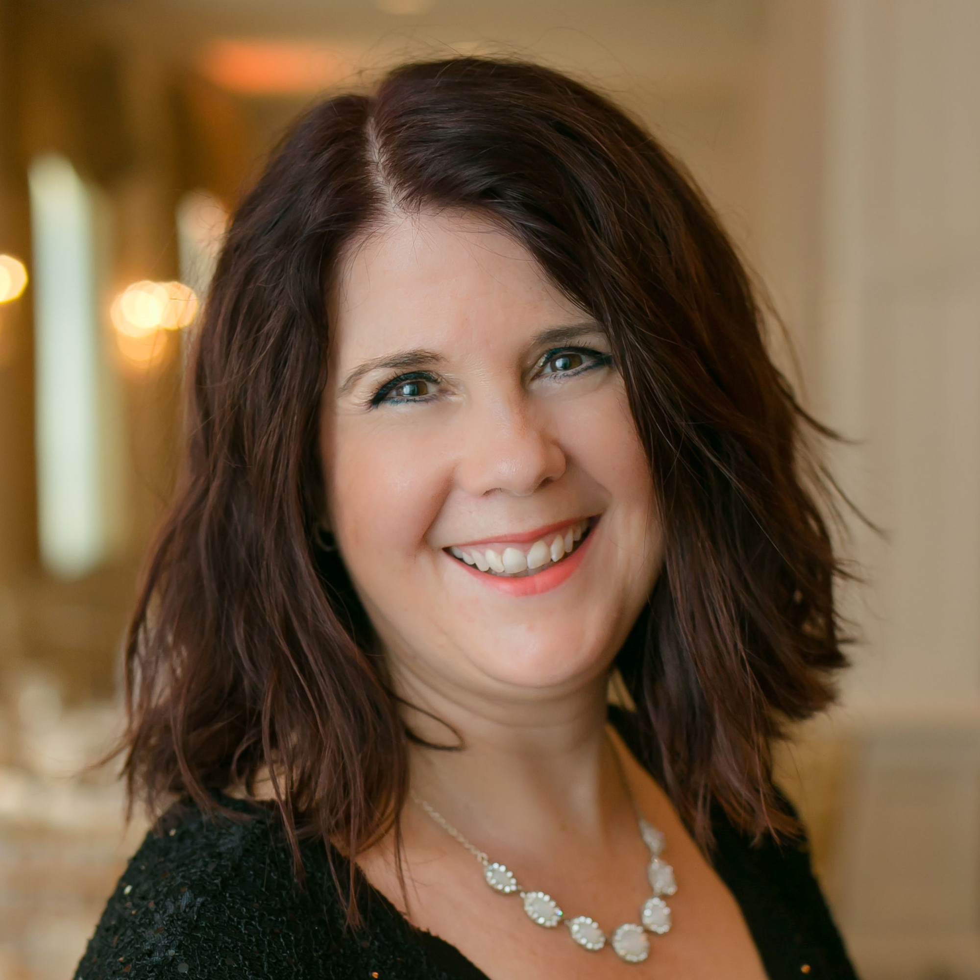 April Donahue smiling at the camera for an upclose headshot.
