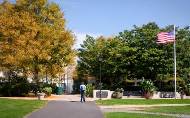 A wide shot of a student walking to the student center. 