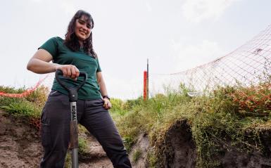 Jaclyn Fiola digging with a shovel in a soil pit. 