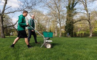 A student is working with doug linde on the field. 