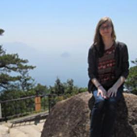 Woman sits on a rock on a hiking path