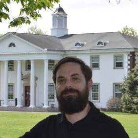 Jonathan Lance is standing outside in front of Work Hall. 