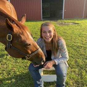 Delaware Valley University animal science student Jalene Beach next to a horse. 