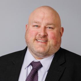 Dr. Broc Sandelin's headshot. His is attire is professional.