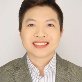 A professional headshot of Keith Ou wearing a brown blazer with blue and white striped button up shirt. 
