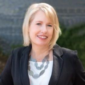A headshot of Heather Harrington smiling and wearing business attire.