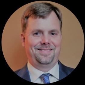 A headshot of Kevin Brightbill wearing a blue suit and tie. 