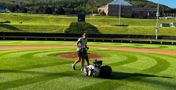 Jillian is working at the little league world series on the turf. 