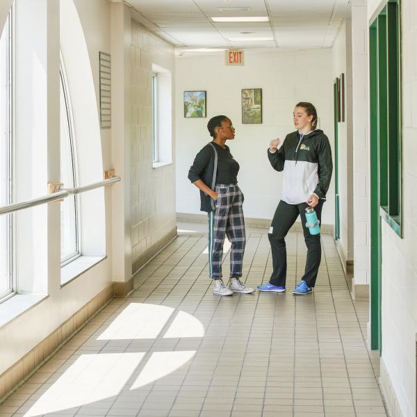 Two students talking in the Student Center hallway