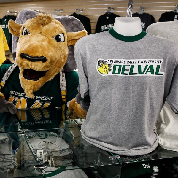 Caesar standing next to a mannequin with a delval t shirt displayed. 