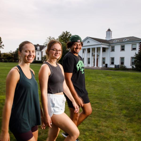 Three students from the College Tour are walking toward the life sciences building