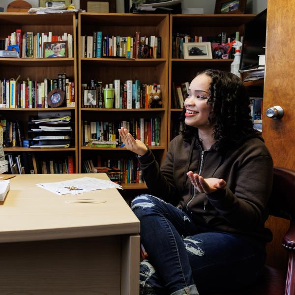 A student is in an academic office setting speaking with an english professor.