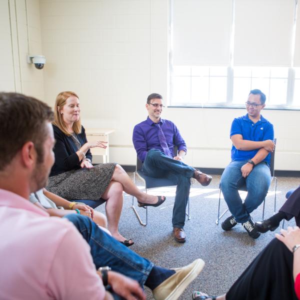 Students are seated in a circle in a Graduate Counseling Psychology class.