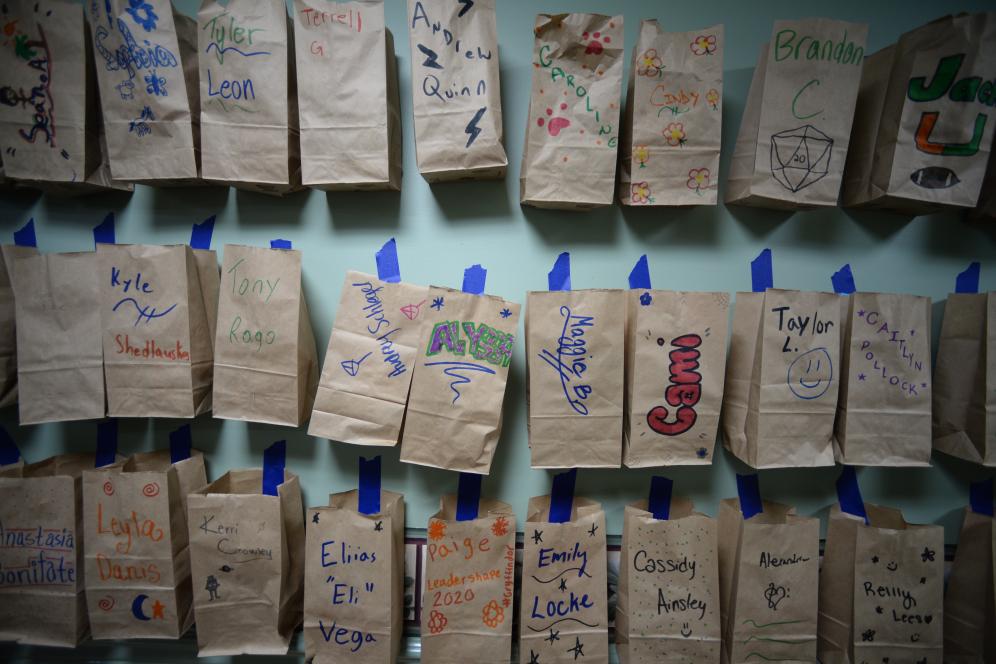 paper bag with names drawn on them taped to the wall