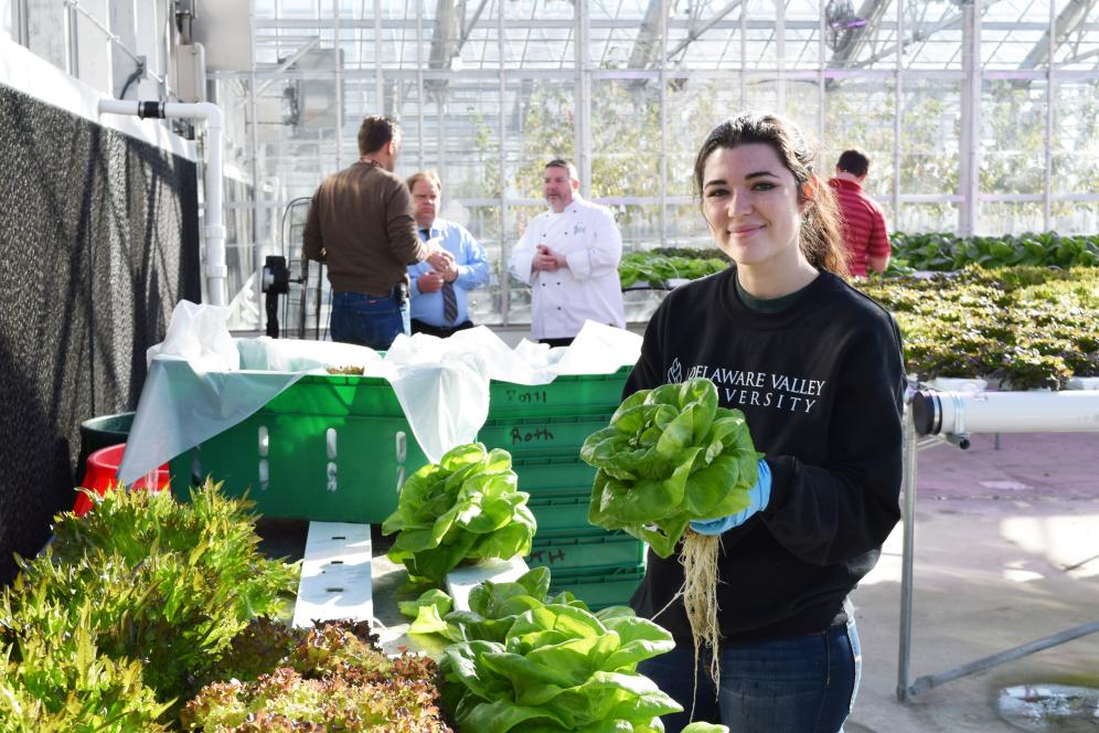 Student holding up fresh produce grown on campus.