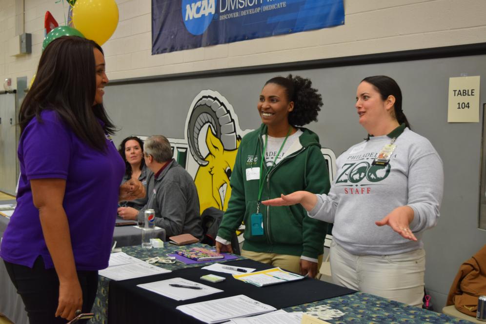 A student speaks with prospective employers at an information table at Delaware Valley University's Job and Internship Fair.