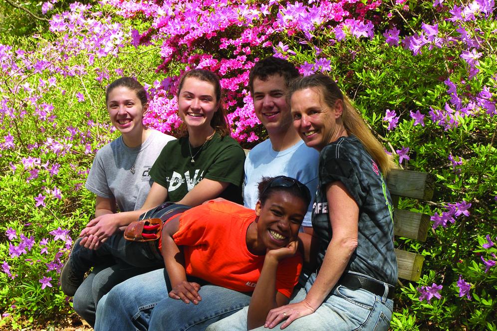 Students gathered on bench in the arboretum