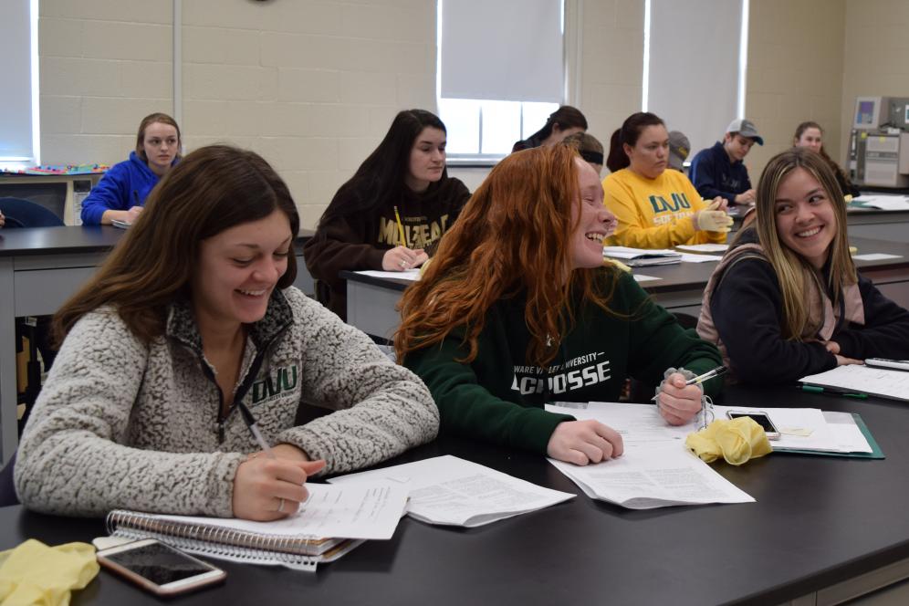 Three students smile in class