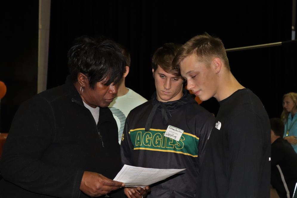 Priscilla Jackson reviews papers with two Delaware Valley University students at a career development event.