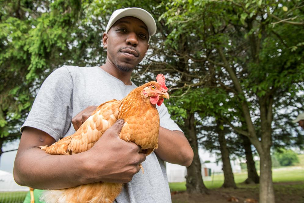 male student holding a chicken