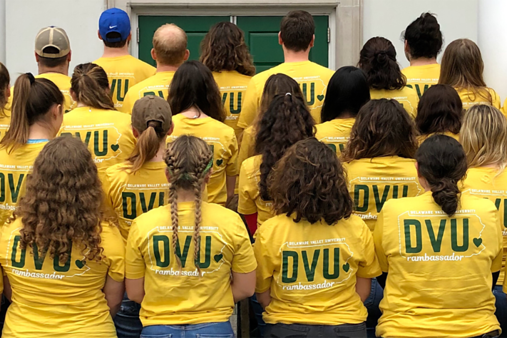 DelVal student ambassadors, known as "RAMbassadors", in their yellow RAM t-shirts with their backs facing camera.