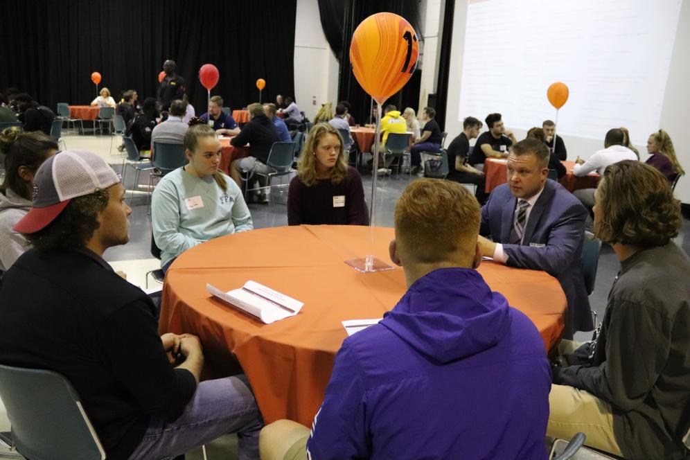 alt ext students networking with alumnus at round table.