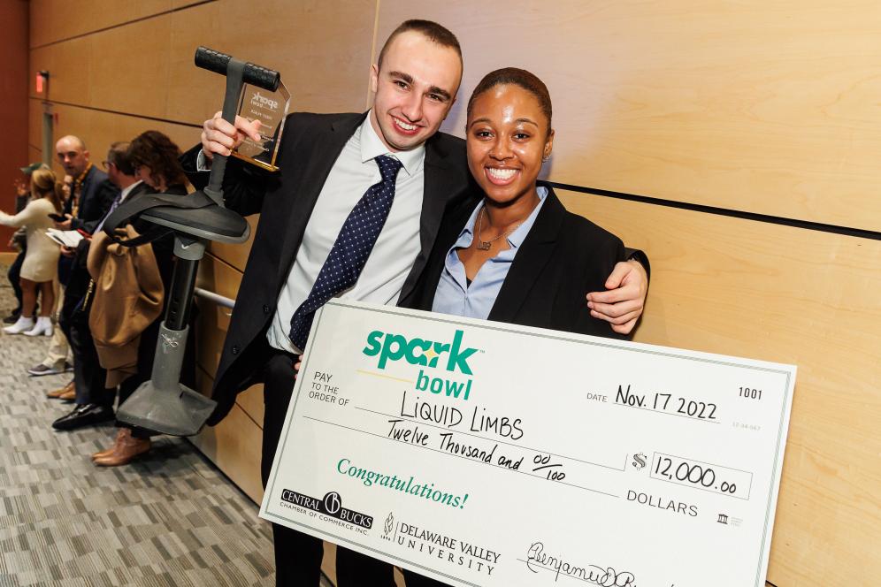 Sparkbowl winners pose with giant checks. 