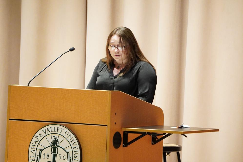 Kayla Leary, a media and communications student, speaking infront of a crowd at a podium.