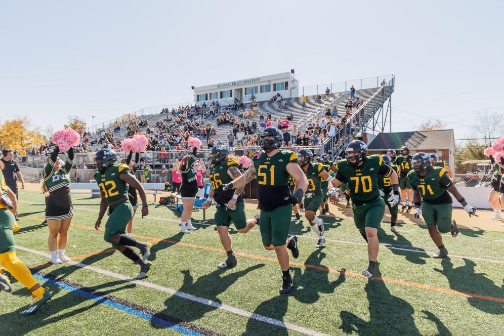 Homecoming 2024 football players running into the field