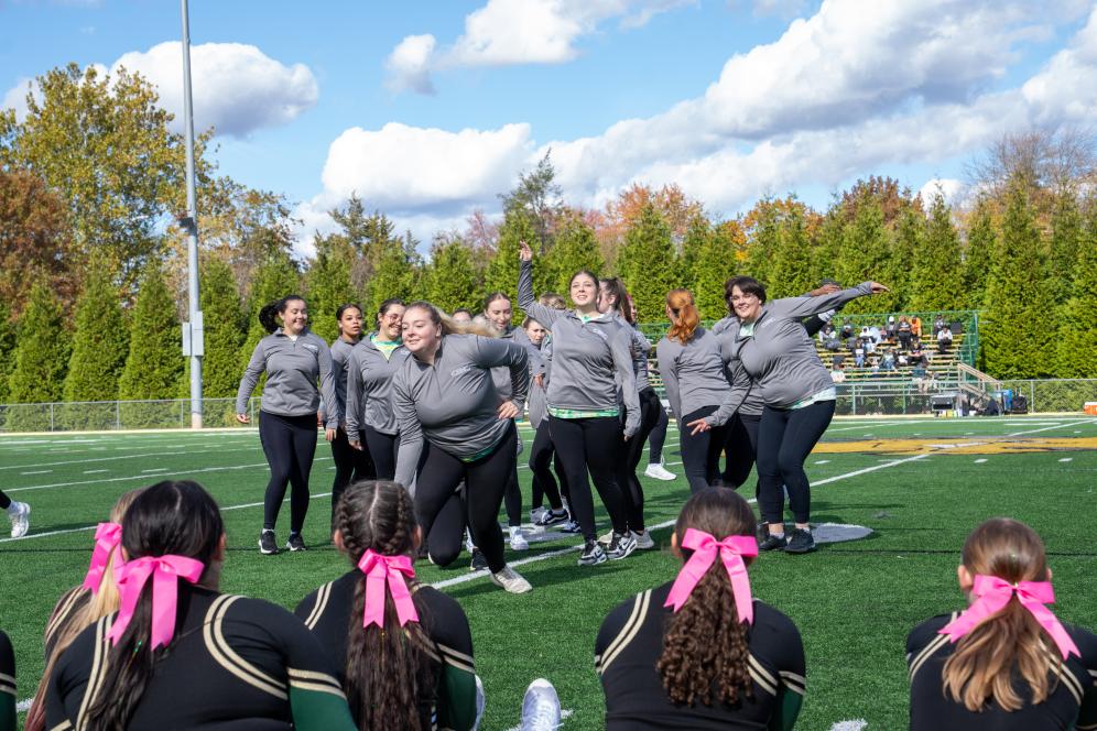 The DelVal Dance Team in 2025, a group on the football field in dance motion.
