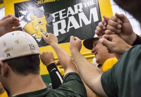 students cheering at game in front of Ram logo
