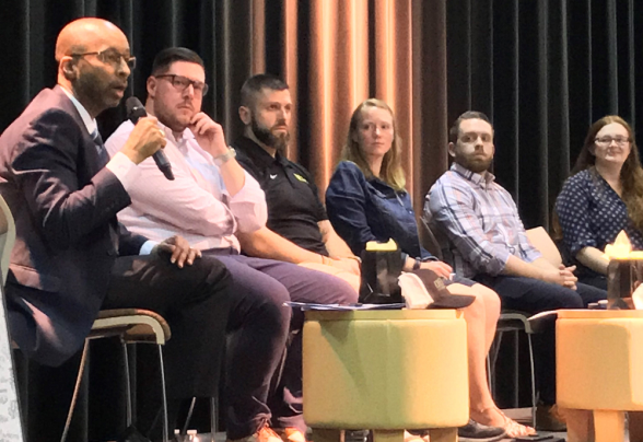 Alumni speaking on a stage to DVU students about life after college.