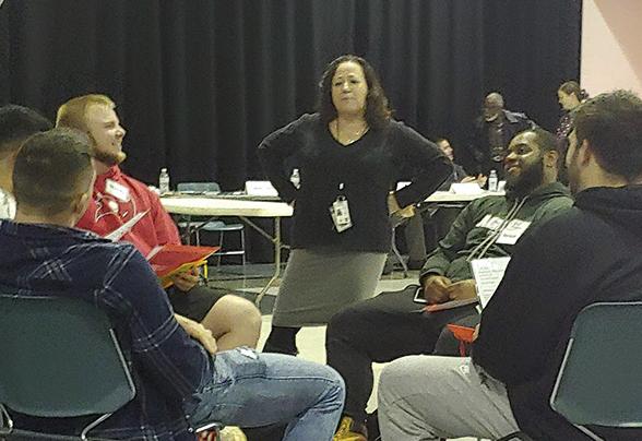 A criminal justice speaker is talking with students sitting in a circle.
