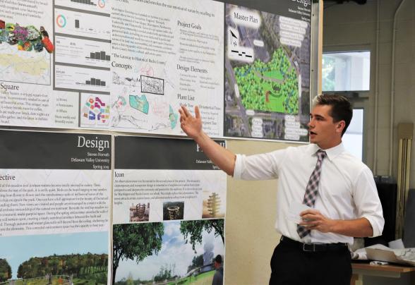 A student is standing and presenting his project 