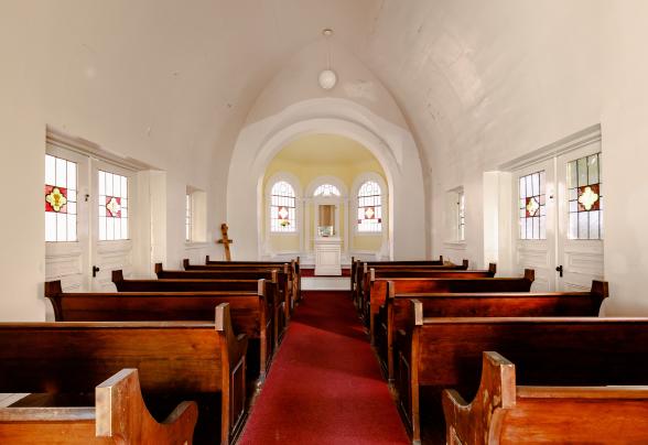 The full view of the chapel's interior. windows, alter, pews