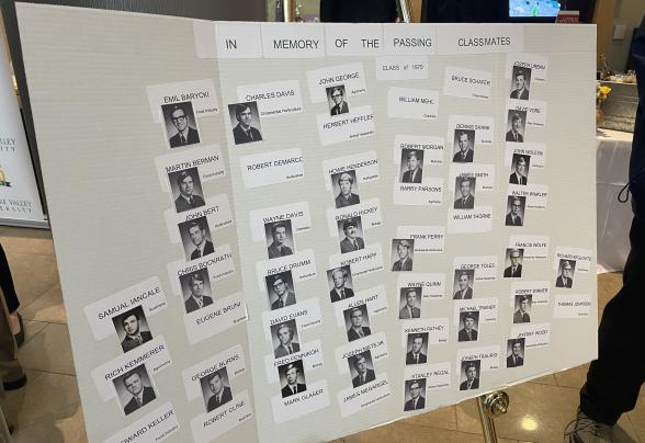 A trifold board of photos of alumni from the Class of 1970 who passed away. 