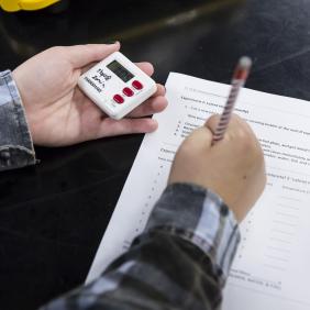 hand of student entering data onto paper