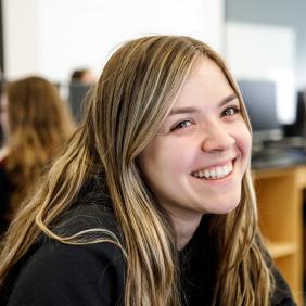 A female student smiling in a classroom