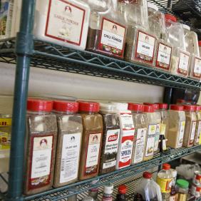 wall with a rack of large spice jars