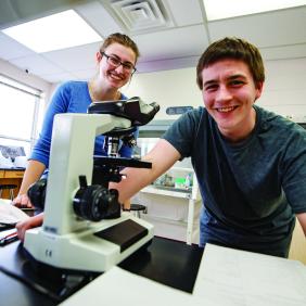 Two students with a microscope