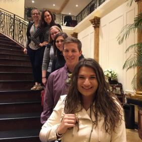 Six students on stairs at a restaurant