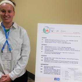 A female student standing in front of her presentation board.