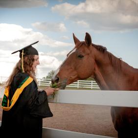 Jillian in a cap and gown with a horse