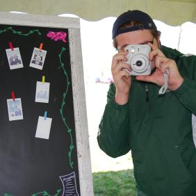 Student takes photos with a polaroid camera. 