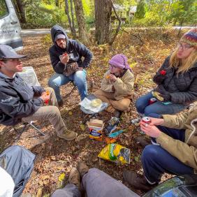 Students are in a soil pit, analyzing soil samples. 