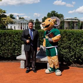 Dr. Ben standing with Caesar the mascot on the quad